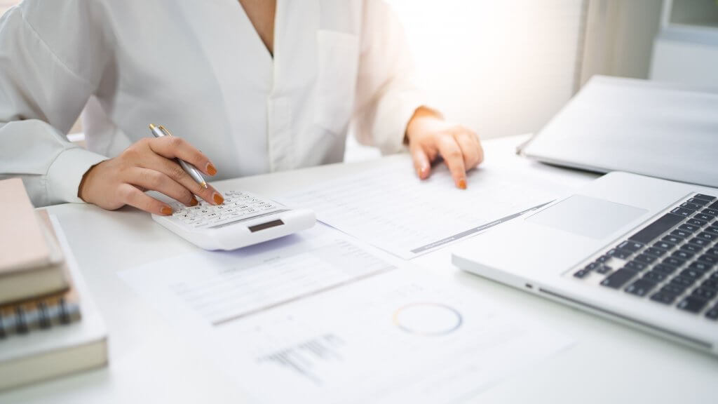 a woman calculating while reading a paper