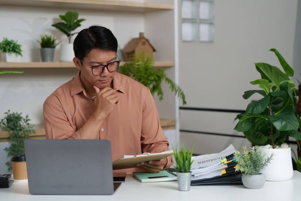 a guy checking the papers on a board