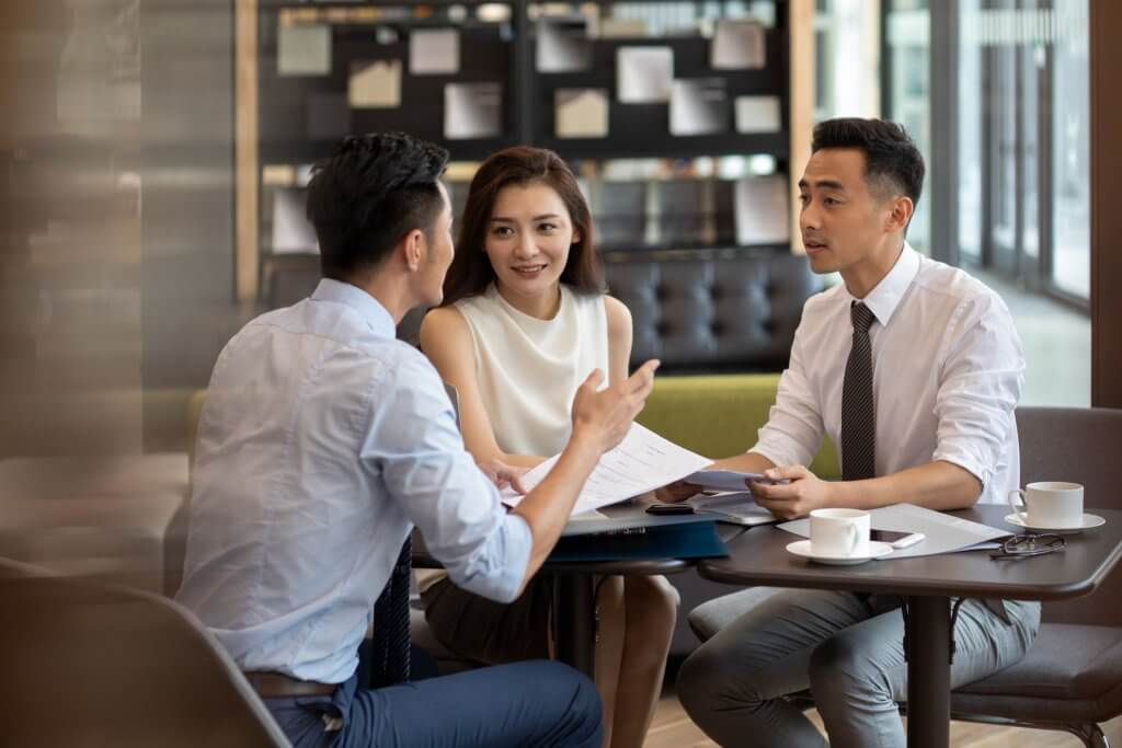 a group of 2 men and a woman having a discussion