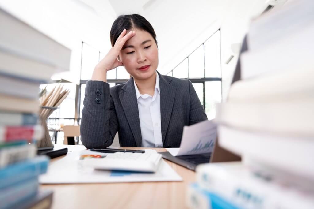 female worker stressing on documents